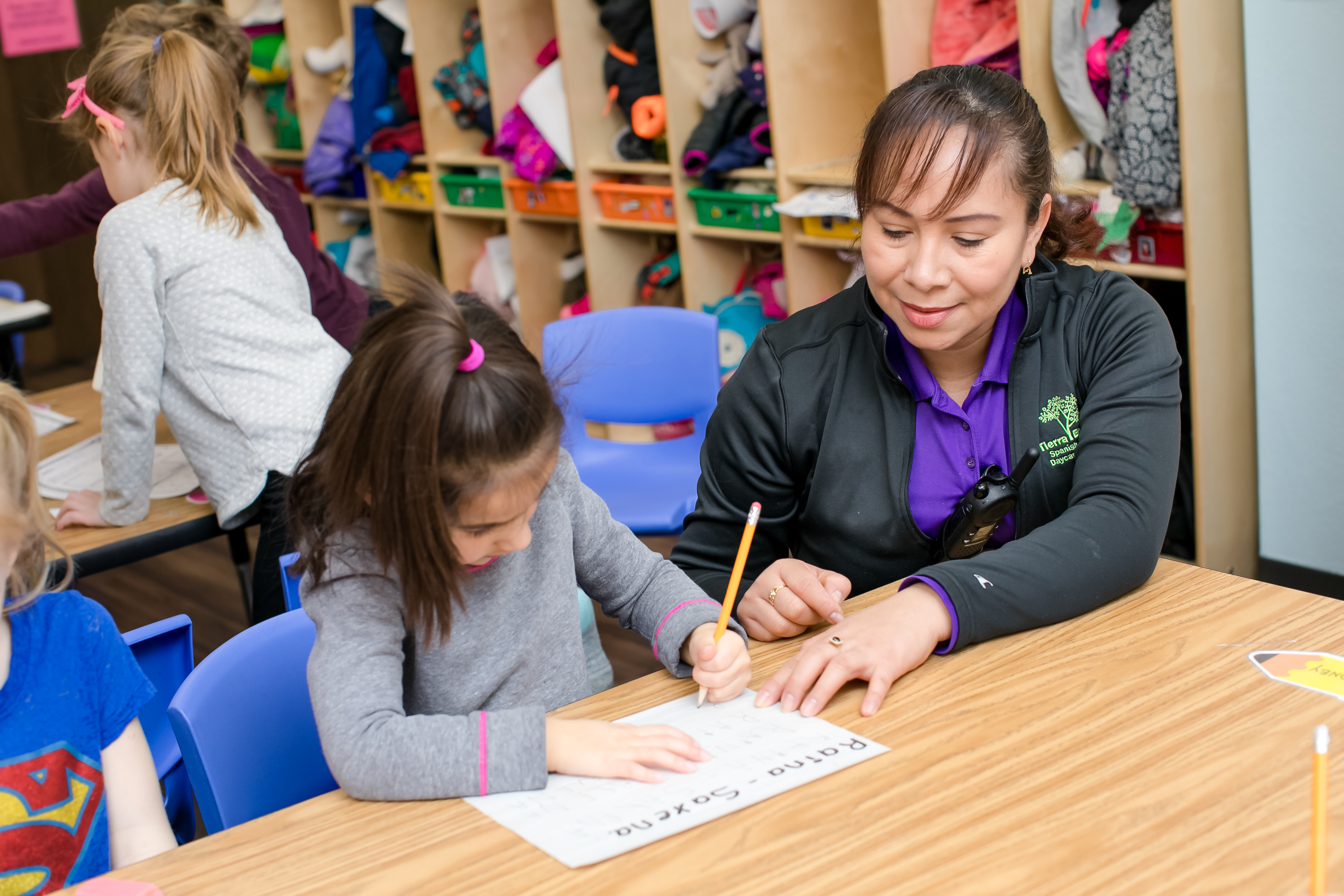 A teacher helps a student with a writing activity